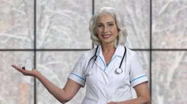 Güzel kadın doktor hapları sunuyor..