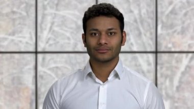 Kameraya bakarak gülümseyen Hintli işadamı.