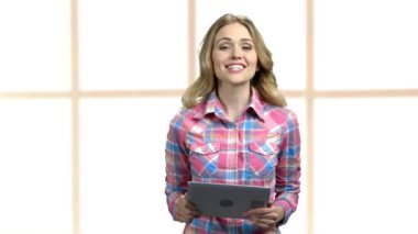 Dijital tabletli genç bir kadın kamerayla konuşuyor..