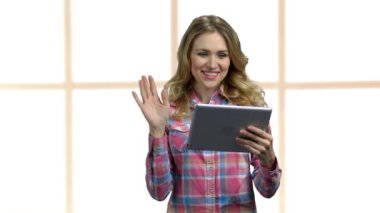 Tablet bilgisayarına el sallayan kadın.