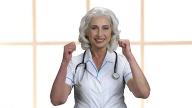 Mutlu kadın doktor iki parmağını kaldırıyor..