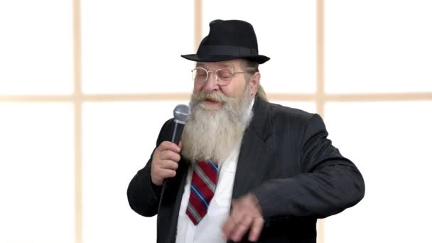 Senior bearded showman talking into microphone. — Stock Video