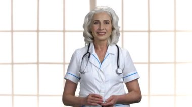 Kadın doktor hapları gösteriyor ve başparmağını kaldırıyor.