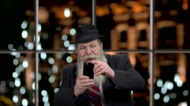 Eski iş adamı cep telefonuyla fotoğraf çekiyor..