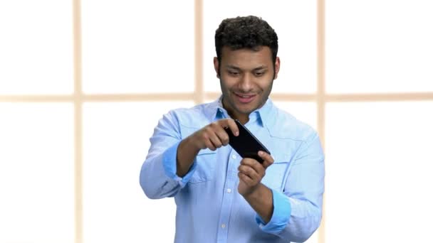 Nadšený obchodník hraje hru na svém telefonu. — Stock video