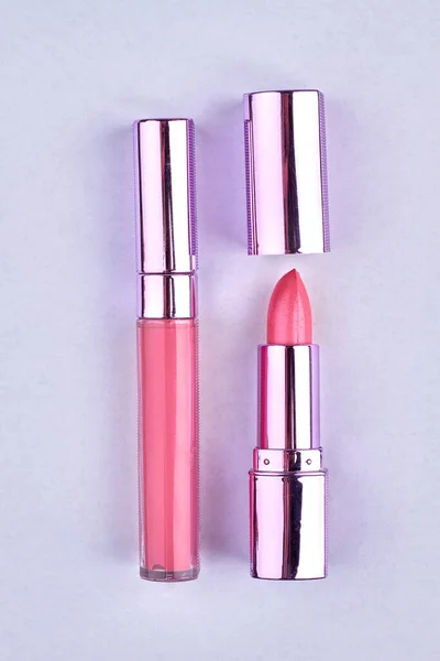 Produtos de maquiagem isolados em fundo branco. Batom rosa e brilho labial. — Fotografia de Stock