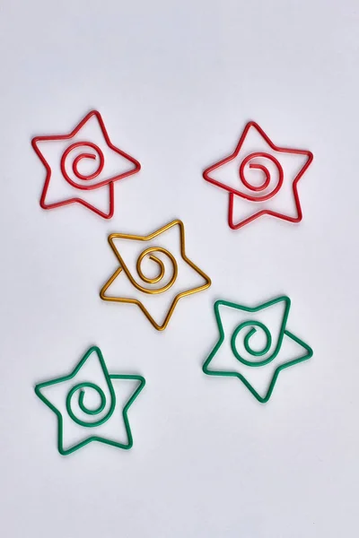 Top view of five-pointed star shaped paper clips on white background.
