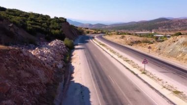 Yazın güneşli bir günde dağlardaki kır yolu manzaralı..