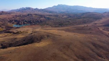 Güneşli bir günde kahverengi yuvarlanan tepelerin manzarası.