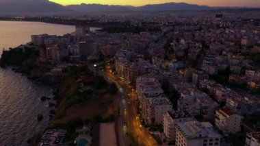 Gün batımında şehir ve deniz manzarası.