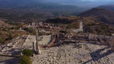 Arkasında dağlar olan şehir harabelerinin havadan görünüşü.