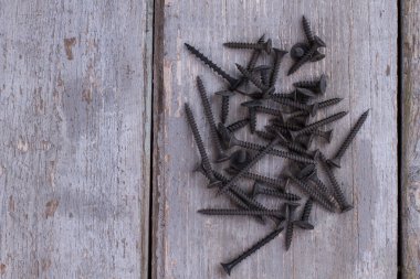 Ahşap arka planda siyah çivi yığını