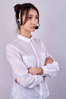 Business woman wearing headset folding her arms.