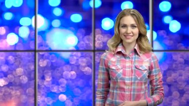 Woman pointing at copy space on bokeh background.
