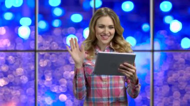 Young woman using pad for video chatting.