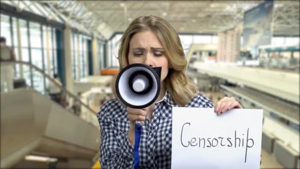 Woman with taped mouth trying to speak into megaphone. — Stock Video