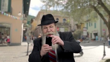 Senior man taking picture with smartphone.