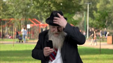 Funny elderly businessman using his smartphone.