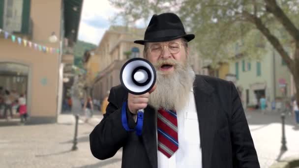 Senior man announcing a message through megaphone. — Vídeo de Stock