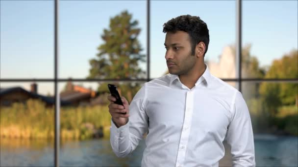 Portret przystojny mężczyzna przy użyciu telefonu komórkowego. — Wideo stockowe