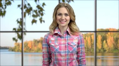 Genç mutlu kadın kameraya başparmağını veriyor..