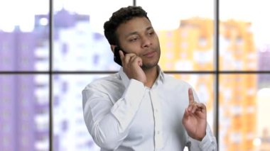 Kendine güvenen iş adamı cep telefonuyla konuşuyor..