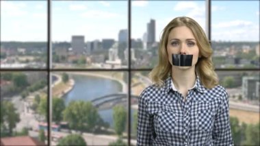 Pretty caucasian girl with black tape over mouth.