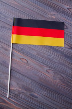 Vertical shot the flag of Germany on grey wooden desk.