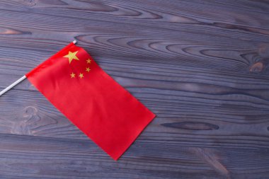 Red wave flag of China on grey wooden desk background.