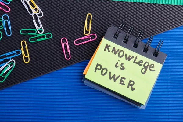 Knowledge is power quote written on the small note book.