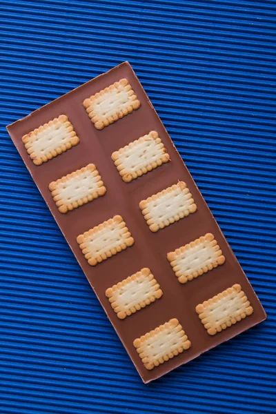 Top view chocolate bar with crunchy cookies on blue background. — Stock Fotó