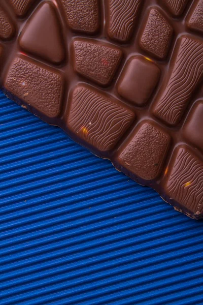 Close-up brown milk chocolate bar on blue background. — 스톡 사진