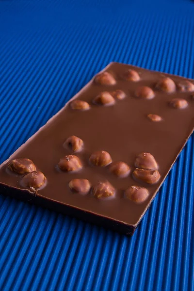 Vertical shot milk chocolate bar with whole hazelnuts. — Foto Stock