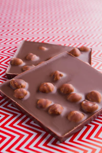 Vertical shot two pieces of chocolate bar with hazelnuts. — Fotografia de Stock