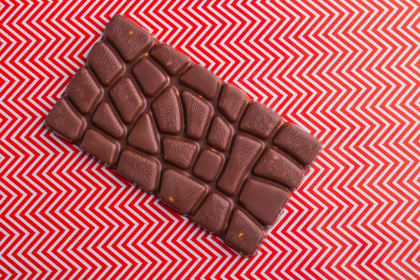 Top view one single chocolate bar on red and white background. — Fotografia de Stock