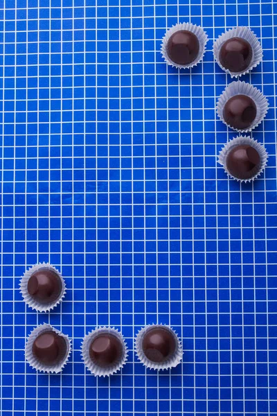 Vertical shot top view flat lay brown chocolate candies and copy space. — Fotografia de Stock