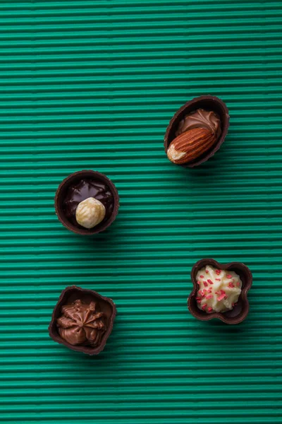 Assortment of brown pralines chocolate candies on green background. — Fotografia de Stock