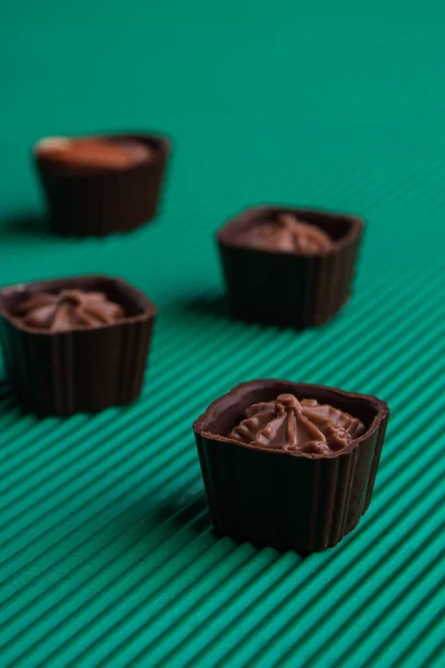 Set of sweet delicious praline brown candies on green background. — стоковое фото