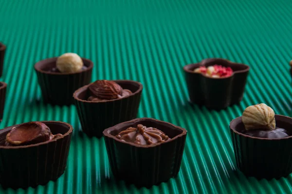 Close-up assortment of sweet unhealthy candies on green background. — Fotografia de Stock