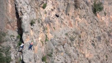 Tırmanan turistlerle dolu büyük kayalık bir uçurum. Turizm ve macera konsepti.