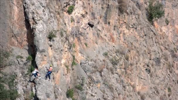 Tırmanan turistlerle dolu büyük kayalık bir uçurum. Turizm ve macera konsepti. — Stok video
