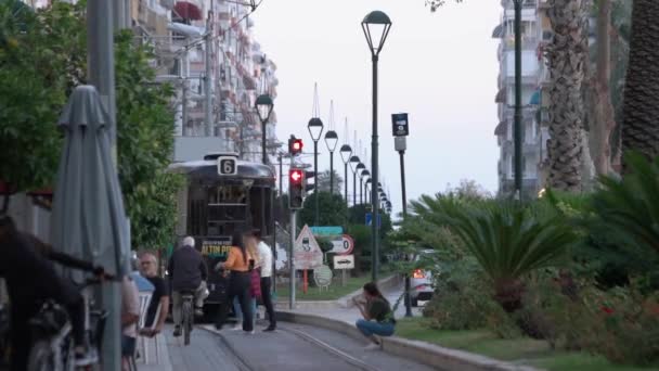 Міський ландшафт з вузькою вулицею, транспортом, людьми і багатоповерховими міськими будівлями. — стокове відео