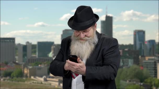 Starší muž ukazující palec nahoru při používání mobilního telefonu. — Stock video