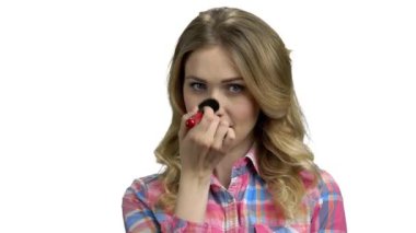 Güzel genç bir kadın kızarmak için fırçayla sarılır.