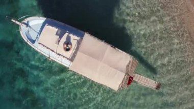 Deniz kıyısında turkuaz suyu olan bir tekne manzarası. Seyahat ve tatil kavramı.