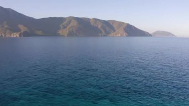 Bir yaz gününde deniz manzarası ve dağlar. Dağların arkasındaki okyanus körfezi..