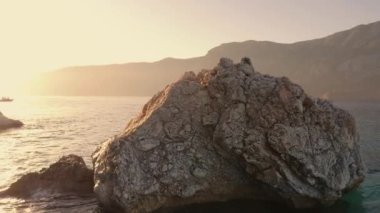 Bir yaz gününde kayalık kıyı ve turkuaz berrak deniz suyu.