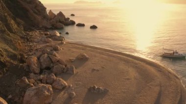 Gün batımında egzotik deniz plajı. Deniz suyundaki teknenin üst görüntüsü.