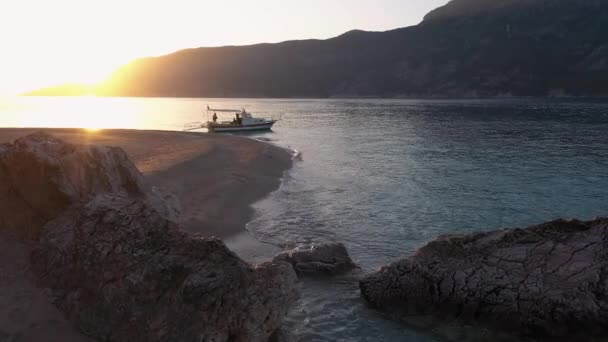 Vue sur la plage sauvage de l'île tropicale au coucher du soleil. Bateau sur le rivage avec des montagnes en arrière-plan. — Video