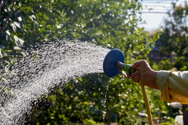 Primer plano viejo caucásico mano sostiene aspersor de agua. — Foto de Stock